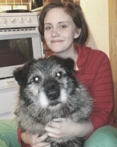 Bild på Vanja, Bengts dotter, som sitter med hunden Gorim i knät.